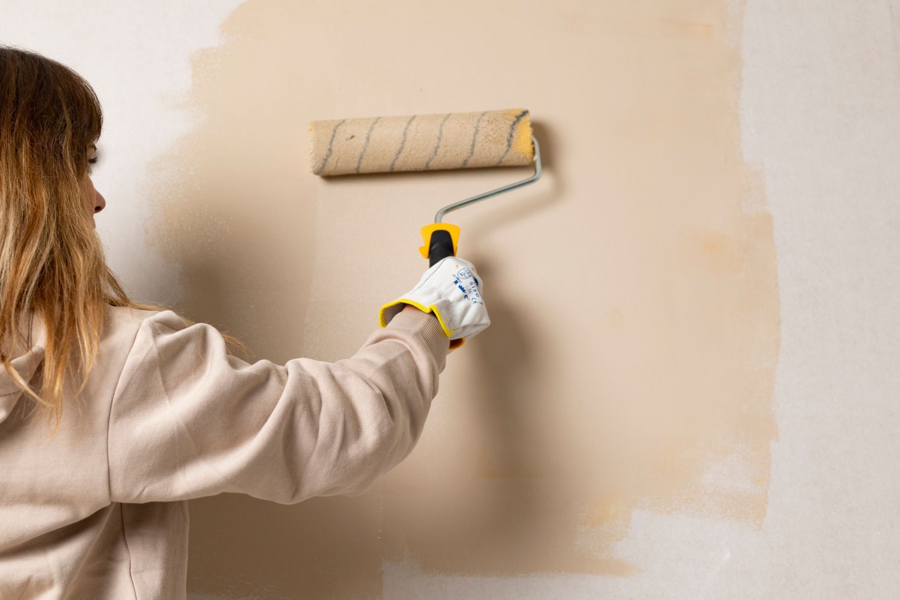 Person painting a wall with matte paint