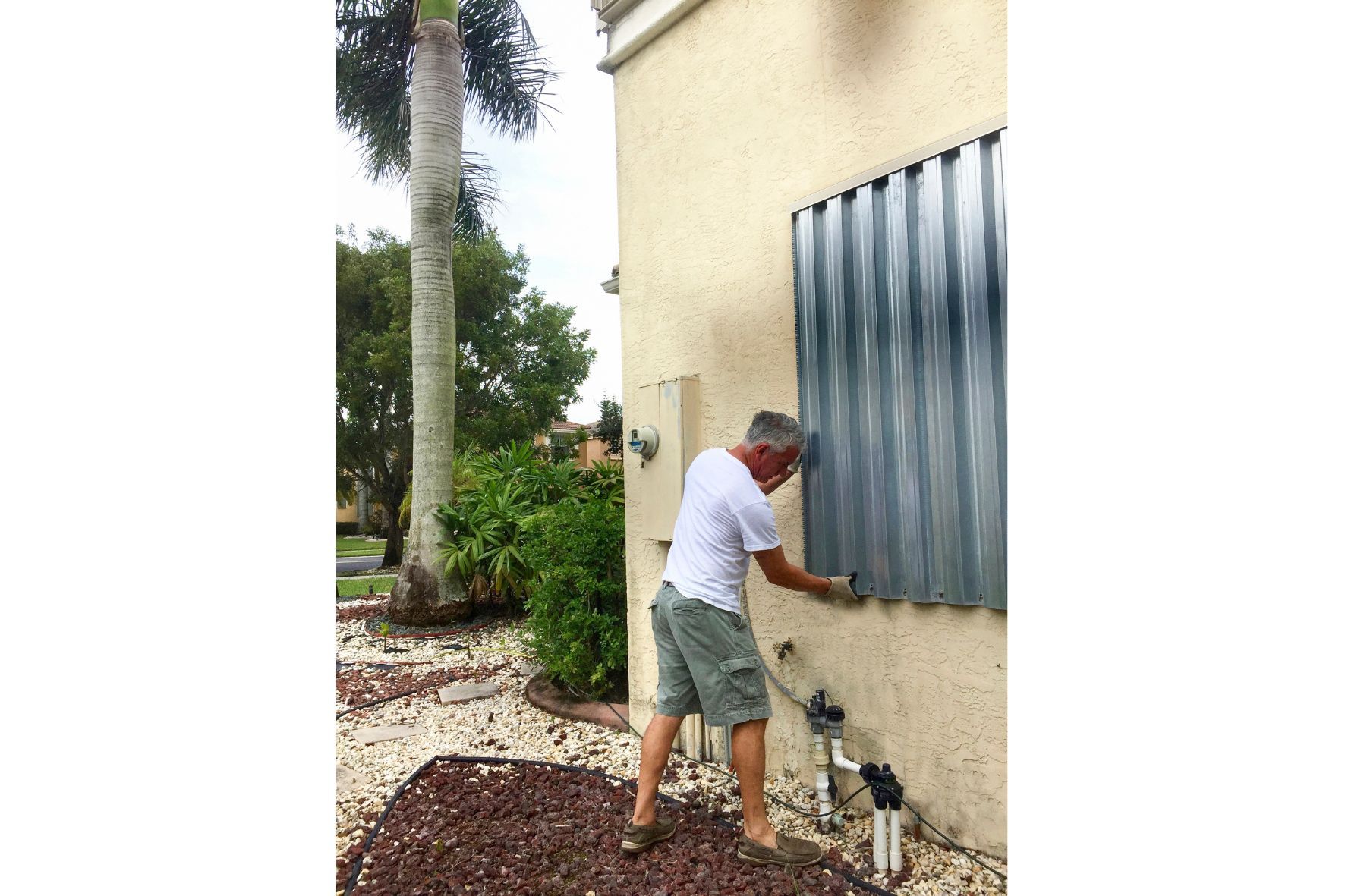 Man installing hurricane shutters on florida home